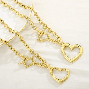 Elegant gold titanium steel jewelry set featuring hollow heart pendants and OT clasps