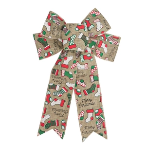 Close-up of burlap Christmas bow with festive stockings and Merry Christmas printing