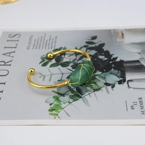 Detailed view of handmade gold wire-wrapped green hexagonal natural stone cuff bracelet