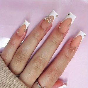 French tip press-on nails with bow rhinestones and gems in a long coffin shape