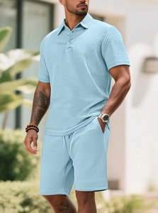 Detail of light blue waffle knit fabric on polo shirt and shorts two-piece set