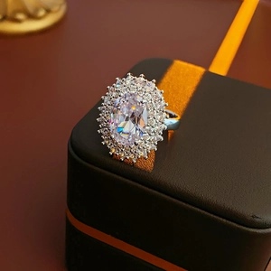 Macro detail of oval zircon halo ring with double-layered pavé set on a jewelry box