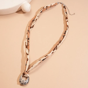 Detailed close-up of floral fabric choker necklace with silver metallic ring pendant