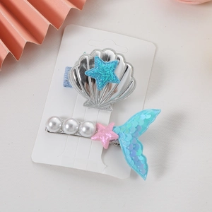 Close-up of glitter mermaid tail and shell hair clips with pearls for girls