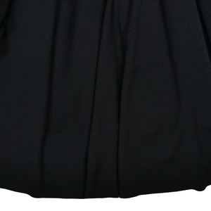 Détail de la texture du tissu noir et du drapé à volants sur la robe sexy dos nu