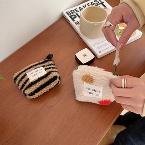 Close-up of plush shearling mini cosmetic pouches with zebra and polka dot patterns
