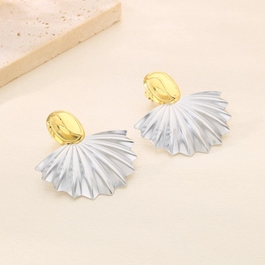 Détail des boucles d'oreilles bicolores en forme d'éventail avec clous ovales dorés