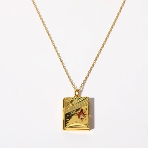 Detail of vintage gold book locket with moon star embossing and sparkling stone inlay