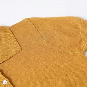 Macro detail of mustard yellow knit POLO shirt collar and textured knit shoulder seam