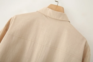 Detailed close-up of beige linen shirt back yoke showing natural fabric texture and stitching
