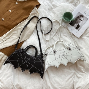 Detail of bat-shaped PU leather handbags in black and white with removable straps