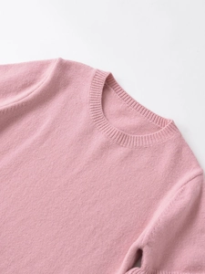 Detail of pink crew neck sweater showing ribbed neckline and soft knit fabric texture