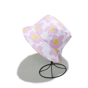 Detail of floral bucket hat featuring pink and yellow flower patterns on white canvas