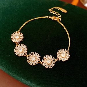 Close-up of vintage flower bracelet with white zircons on dark green velvet background