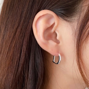 Close-up of minimalist S925 sterling silver D-shaped hoop earrings on a model ear