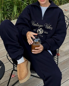 Détail du sweat à demi-zip bleu marine avec emblème Vintage Vibes et écusson couronne