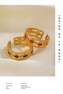 Close-up of gold-plated open rings with red and black enamel evil eye diamond pattern