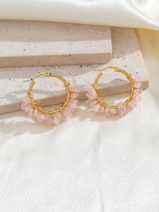 Detail of bohemian gold hoop earrings with handmade pink natural crystal stone wrapping