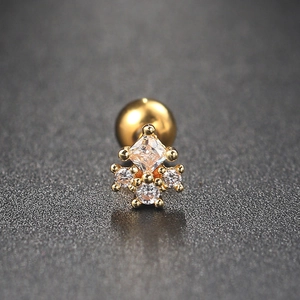 Macro shot of gold-plated stud earring with five white zircons and a screw back