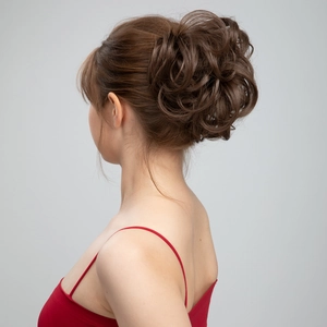 Détail macro d'un chignon ondulé décoiffé en brun foncé sur une femme modèle