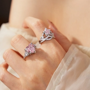 Close-up of heart and star zircon rings in silver finish on hand with soft fabric