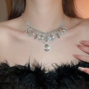 Close-up of sparkling diamond teardrop tassel necklace on model for luxury gala style