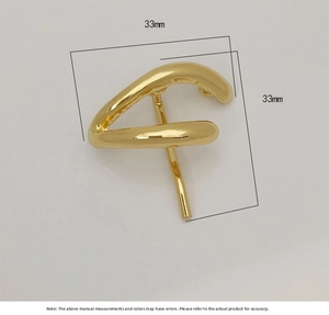 Macro shot of 33mm gold alloy hair clip with polished abstract curved metal surface