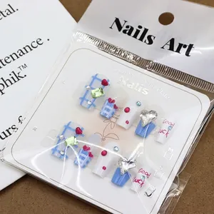 Blue plaid handmade press-on nails with heart sequins and rhinestones set on card