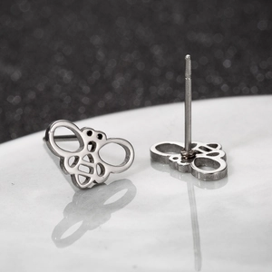 Macro view of silver hollow bee stud earrings in polished stainless steel with details