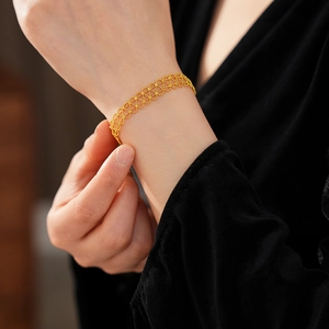 Close-up of gold-plated lace hollow geometric bracelet worn on a female wrist