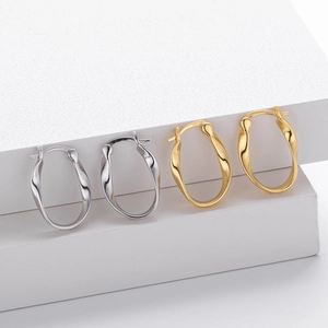 Detail view of Mobius wave earrings in gold and silver showing S925 hallmark