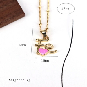 Gold beaded chain necklace featuring a FE letter pendant with pink enamel heart detail