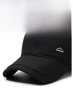 Close-up of durable black cotton baseball cap showing metal badge and stiff curved brim