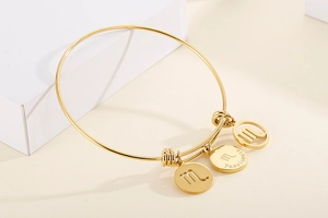 Close-up of golden Scorpio zodiac wire bracelet featuring engraved passionate charms