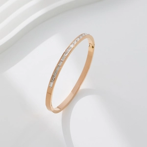 Close-up of rose gold stainless steel bangle with rectangular clear cubic zirconia