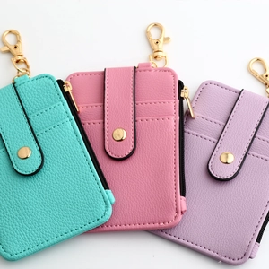 Close-up of litchi texture leather card holders with zipper and lobster clasp