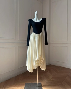 Close-up of contrast patchwork dress with slim black bodice and ivory pleated bubble skirt
