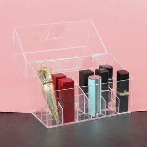 Macro shot of 12-slot clear acrylic lipstick organizer with hinged lid on pink background