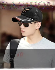 Detail of black baseball cap featuring golden eagle embroidery and white brim stitching