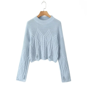 Close-up of light blue cropped cable knit sweater with distressed hem and cuffs detail