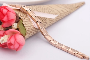 Detail eines roségoldenen Edelstahl-Gliederarmbands mit Germaniumsteinen auf Requisiten