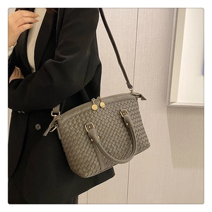 Détail rapproché de la texture tressée gris foncé avec fermeture éclair en métal rond