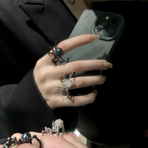 Gothic black spider ring with moonstone details on a person's hand in punk style