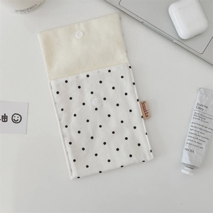 Detailed view of polka dot canvas storage bag with snap button and woven logo tag