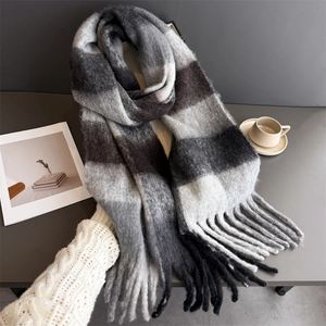 Détail d'une écharpe à carreaux gris doux avec texture épaisse et esthétique hivernale