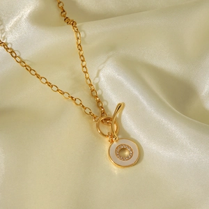Detailansicht einer goldenen Edelstahl-Halskette mit Muschel und Pavé-Steinen