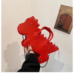 Close-up of red dinosaur handbag featuring silver metal rivets and versatile chain strap