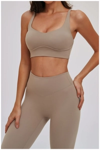 Detail van licht kaki sportbeha met uitgesneden rug en yoga legging met hoge tailleband