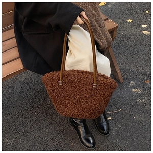 Gros plan d'un sac cabas en fausse fourrure marron avec anses fines en cuir