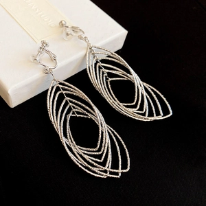 Macro detail of silver layered oval leaf clip-on earrings with textured metal surface